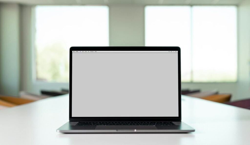 An open laptop computer sitting on a bright white desk