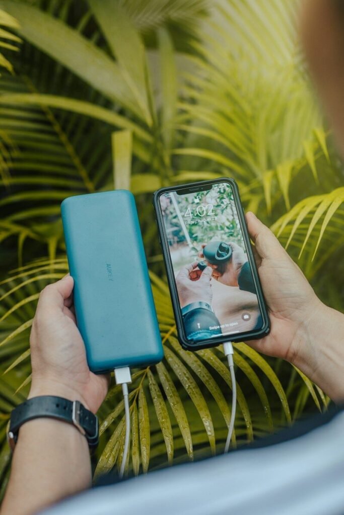 Hand holding a green portable power bank charging a smartphone, illustrating portable power banks explained