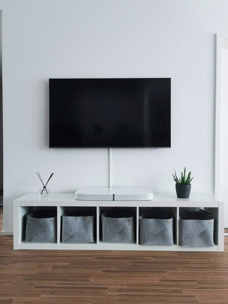 Flat-screen TV mounted on a living room wall above a white media console, illustrating a budget 4K TV buying guide