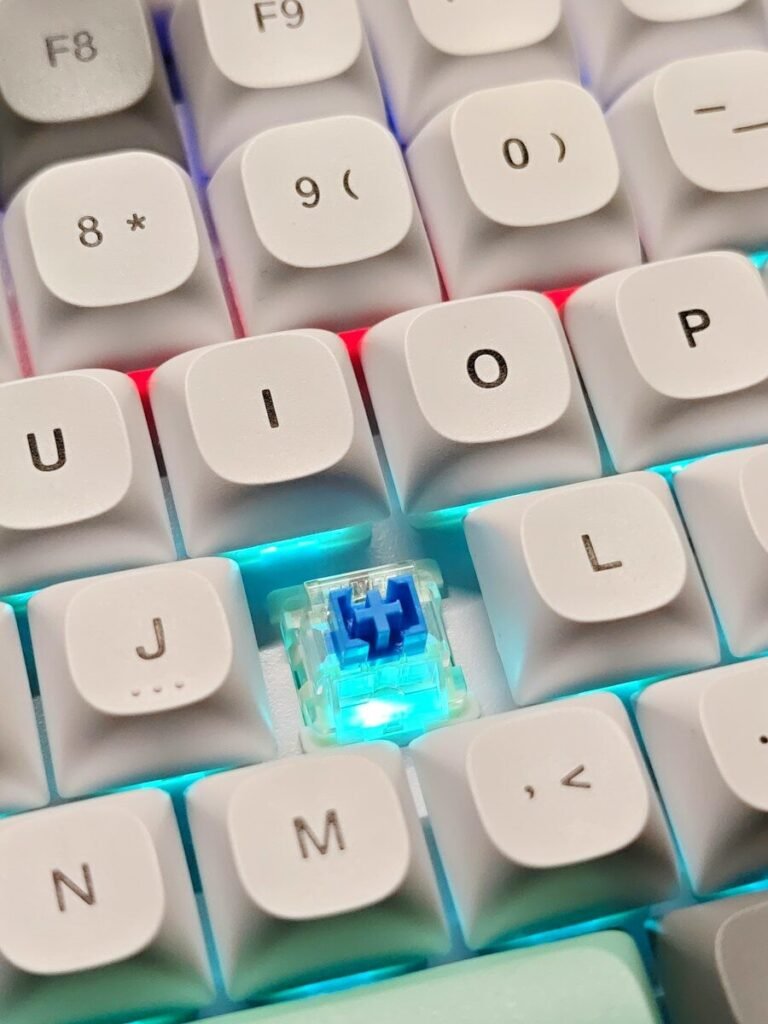 Close-up of a white mechanical keyboard with blue switches and white keycaps, illustrating a beginner guide to mechanical keyboards